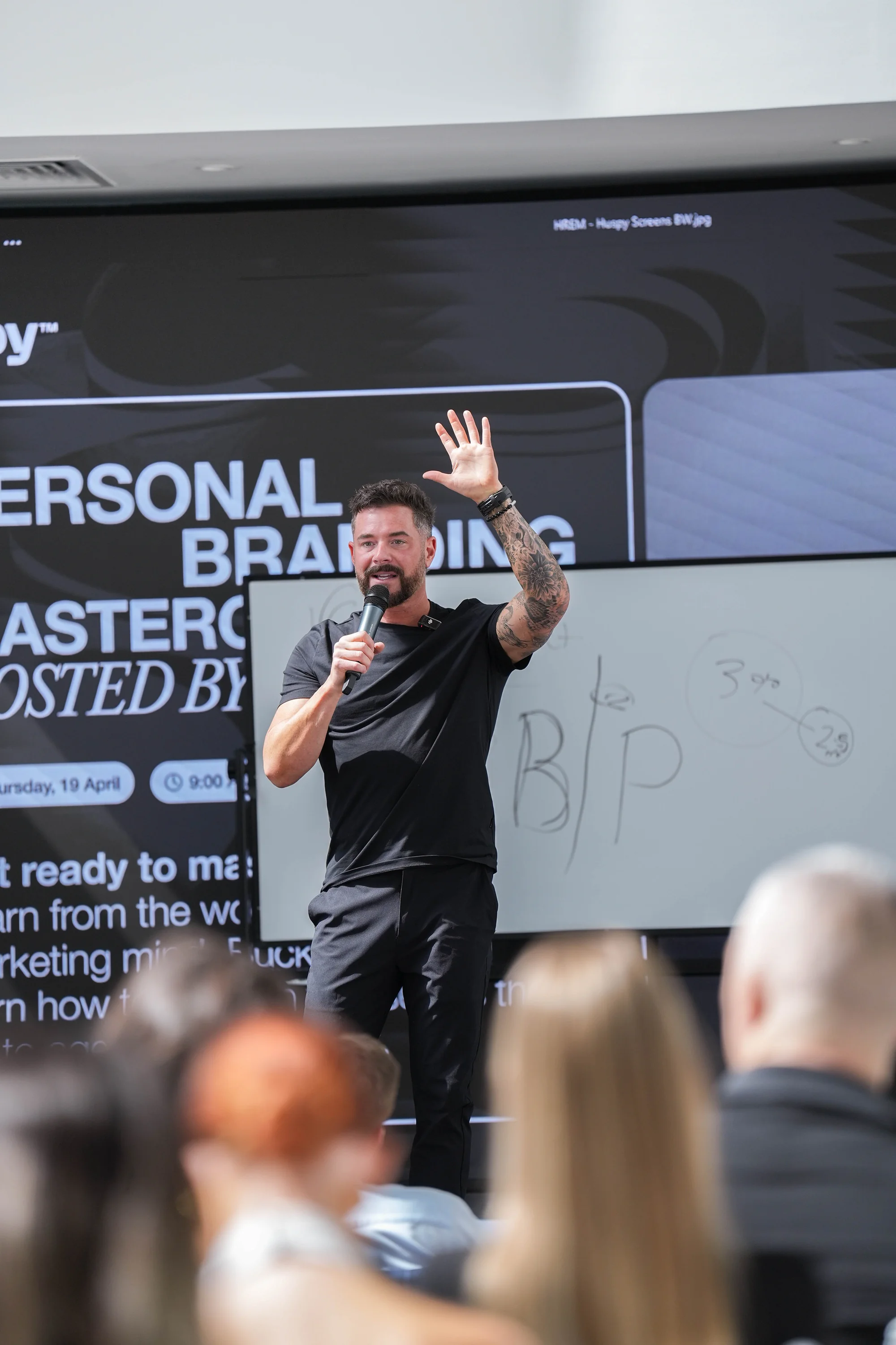 Buck Wise speaking on stage hand raised